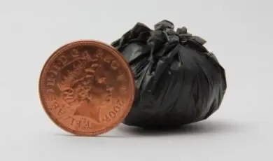 A tied garbage bag, ready to be put out to the trash can. | God pris